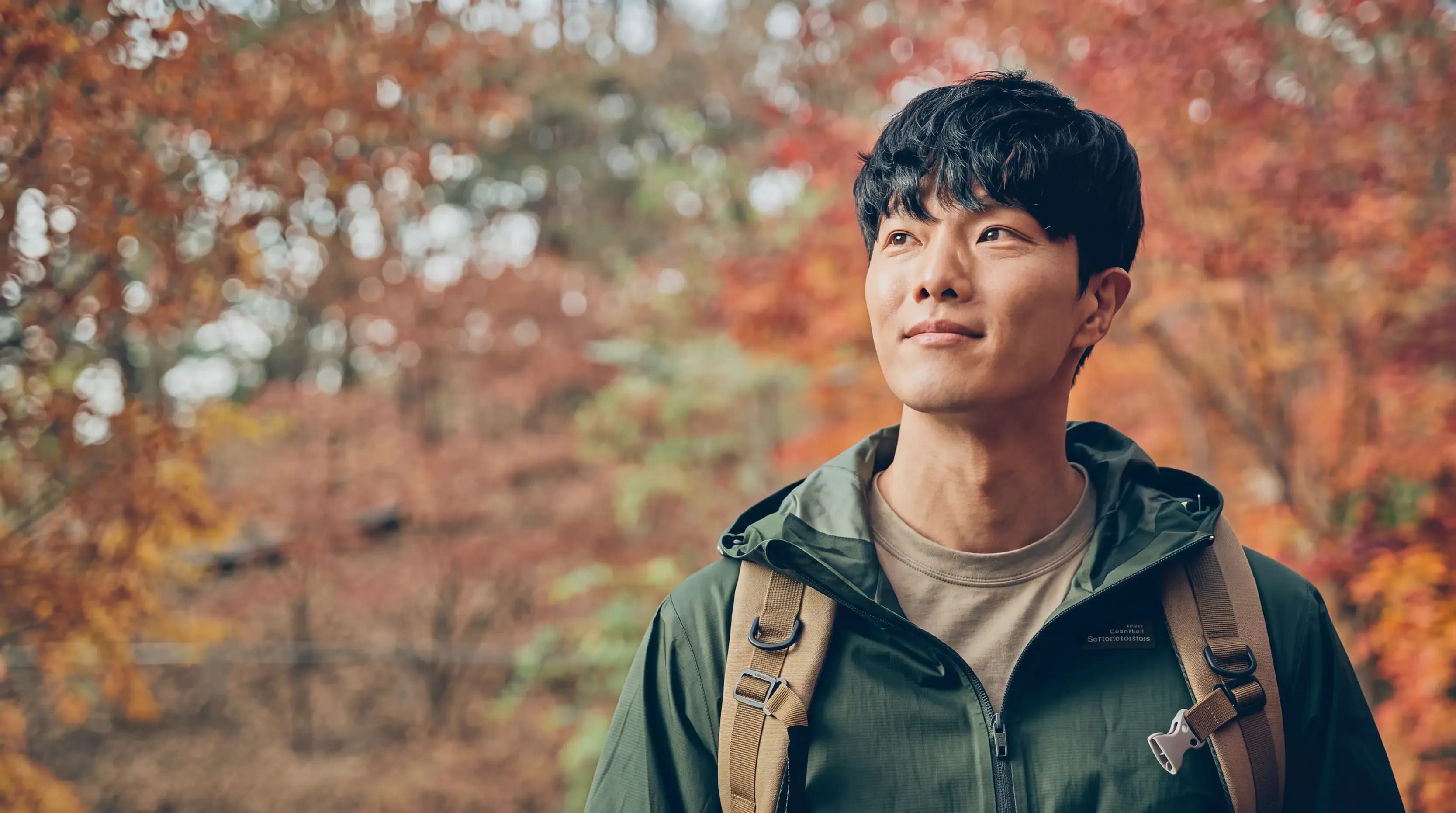 가을 단풍이 든 숲에서 배낭을 메고 서 있는 등산객